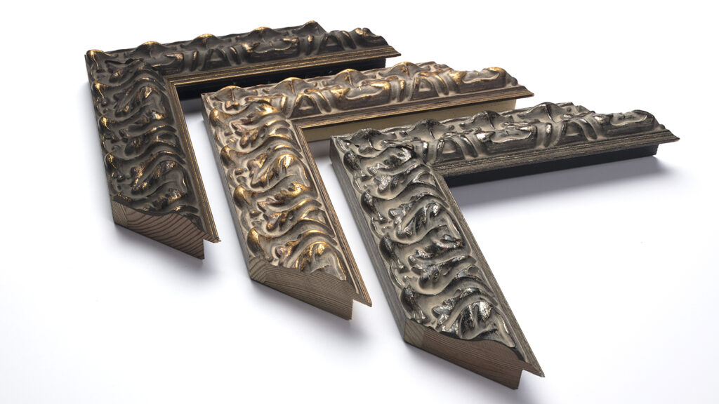 Three ornate, decorative picture frame corners with intricate raised patterns, arranged on a white background.