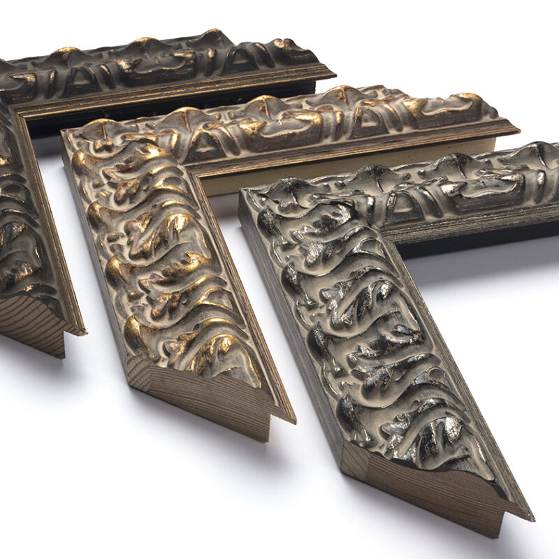 Three ornate, decorative picture frame corners with intricate raised patterns, arranged on a white background.