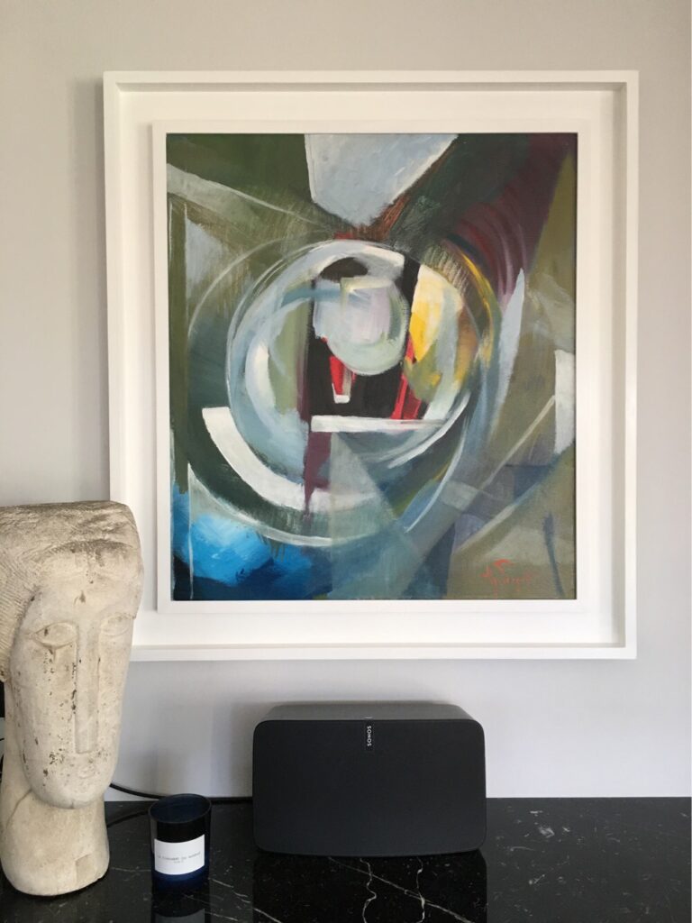 An abstract painting in a white frame