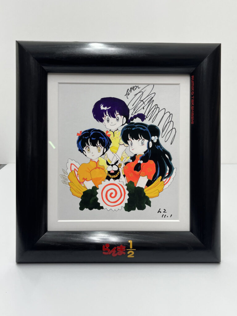 Framed illustration of three anime characters with autographs, featuring "Ranma ½" logo in red enamel carved into the polished black picture frame