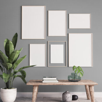 Multiple white frames hanging on a grey background