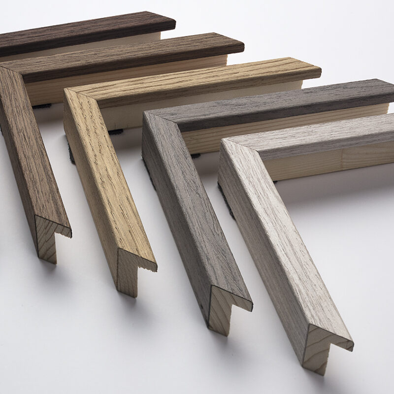 Seven L-shaped wood samples in various shades arranged in a fan pattern on a white surface.