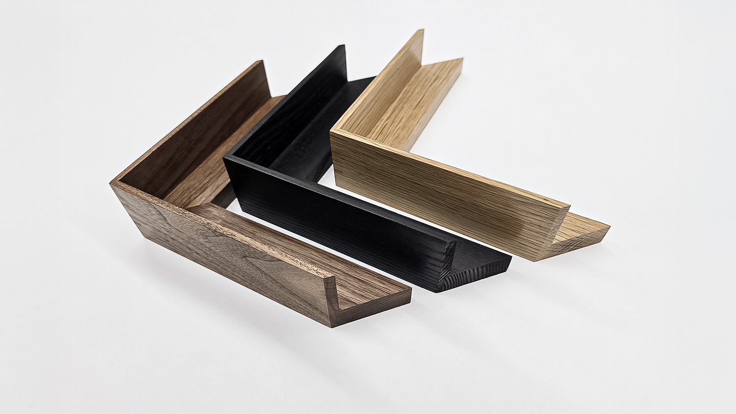 Four L-shaped wooden frame corners in varying wood tones arranged on a white background.