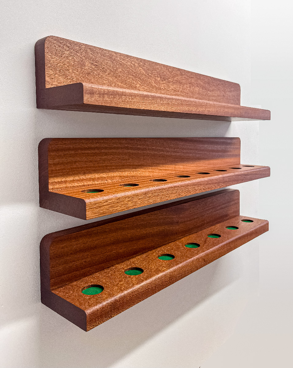 Three wooden wall shelves, two with evenly spaced circular cutouts, mounted on a white wall.