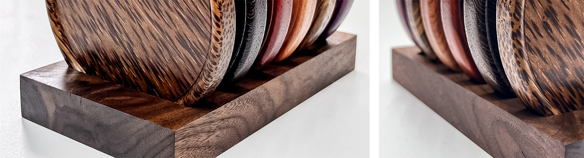 A carved walnut wood stand holds several round coasters of different coloured woods arranged vertically.