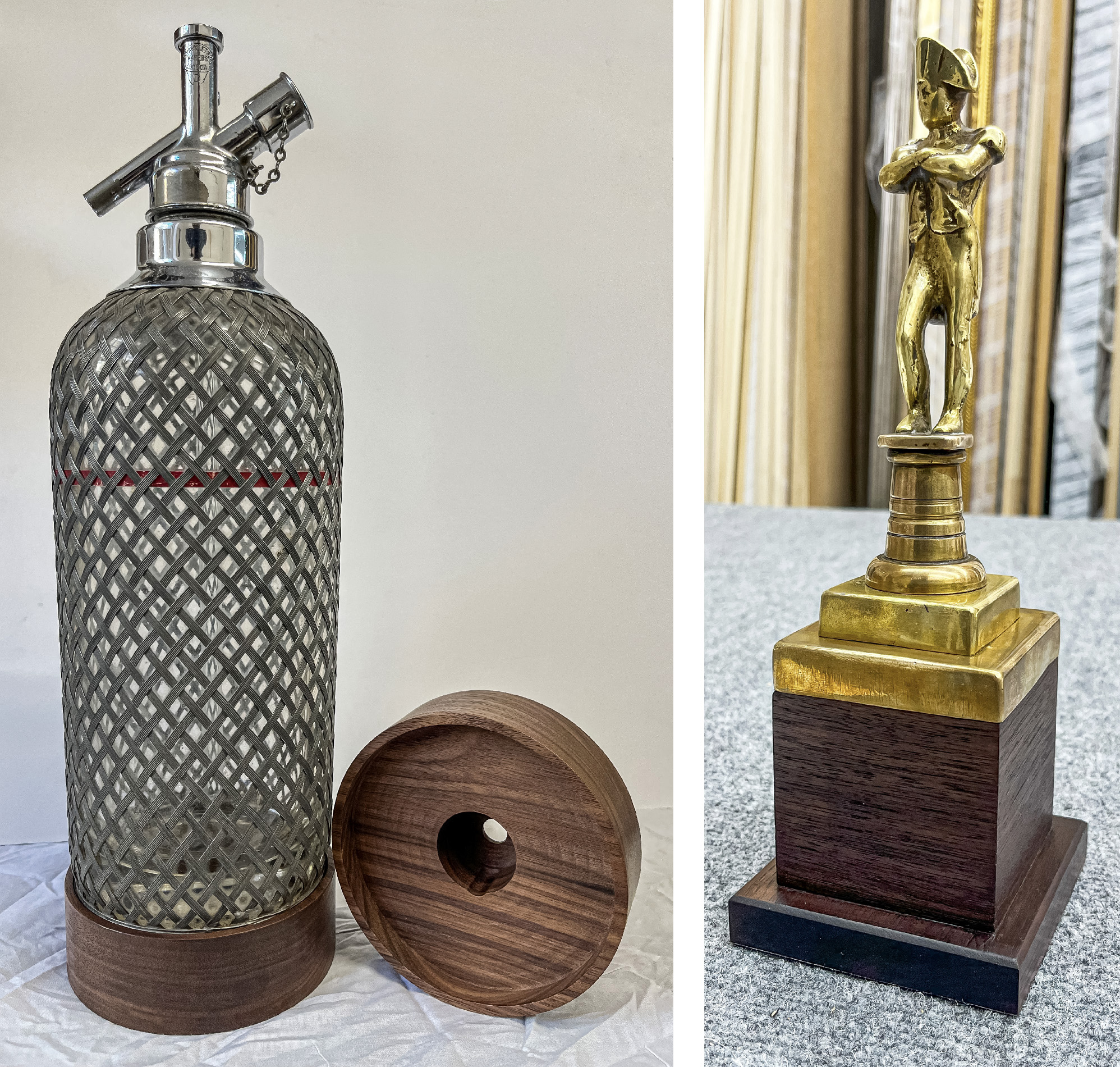 A vintage seltzer bottle with a custom carved walnut base next to a gold figurine on a wooden plinth.