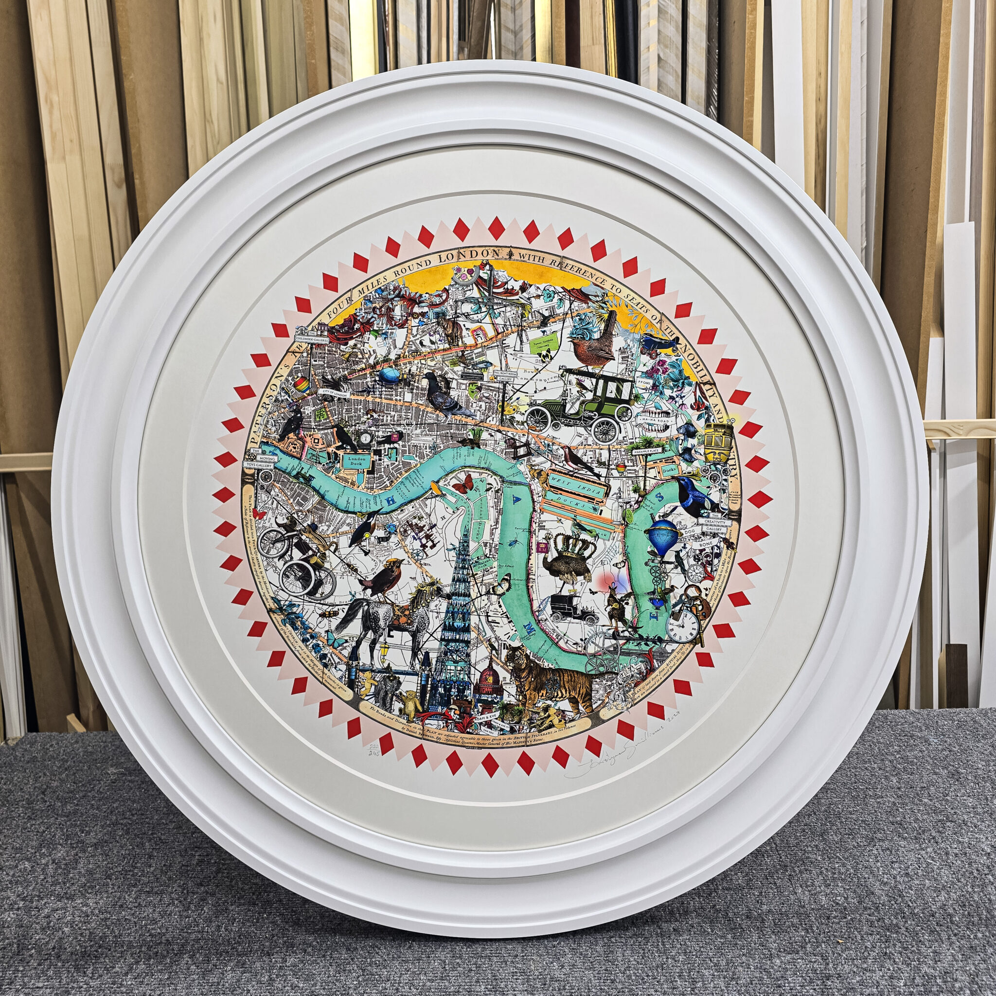 Circular artwork depicting a colorful illustrated map of London with landmarks and icons, framed round.