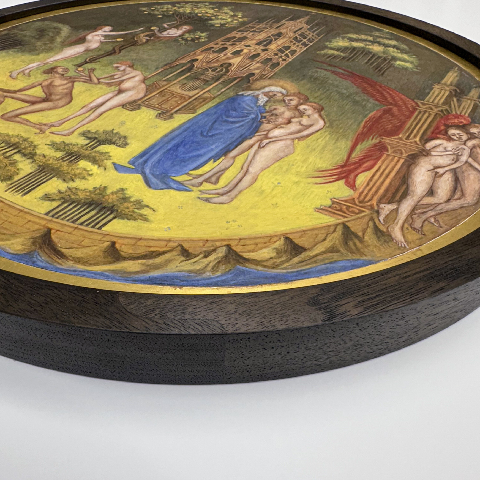 A circular painting depicts biblical figures, trees, a tower, and blue mountains in the background.