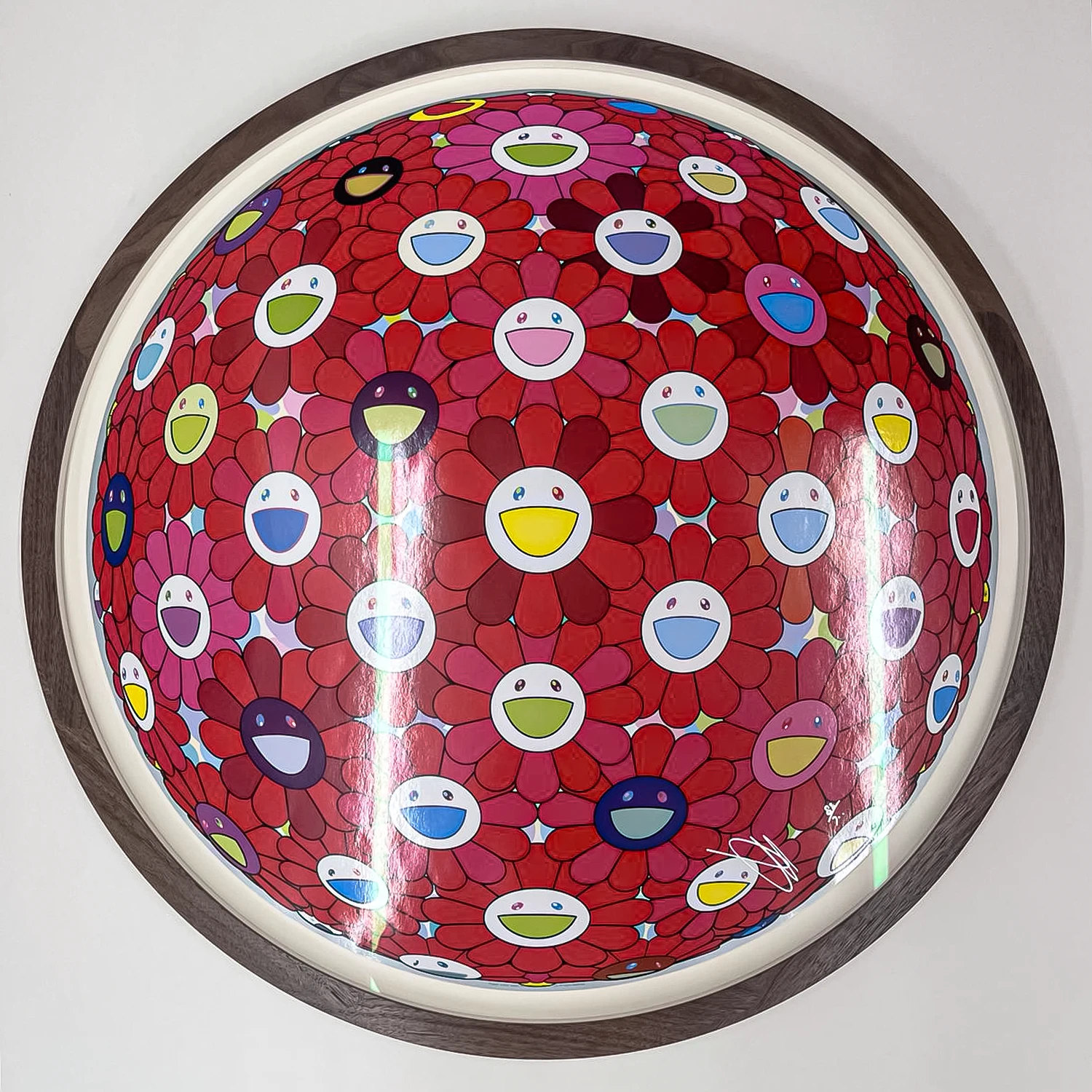 Circular picture frame made from polished brown walnut for a graphic artwork of faces on red