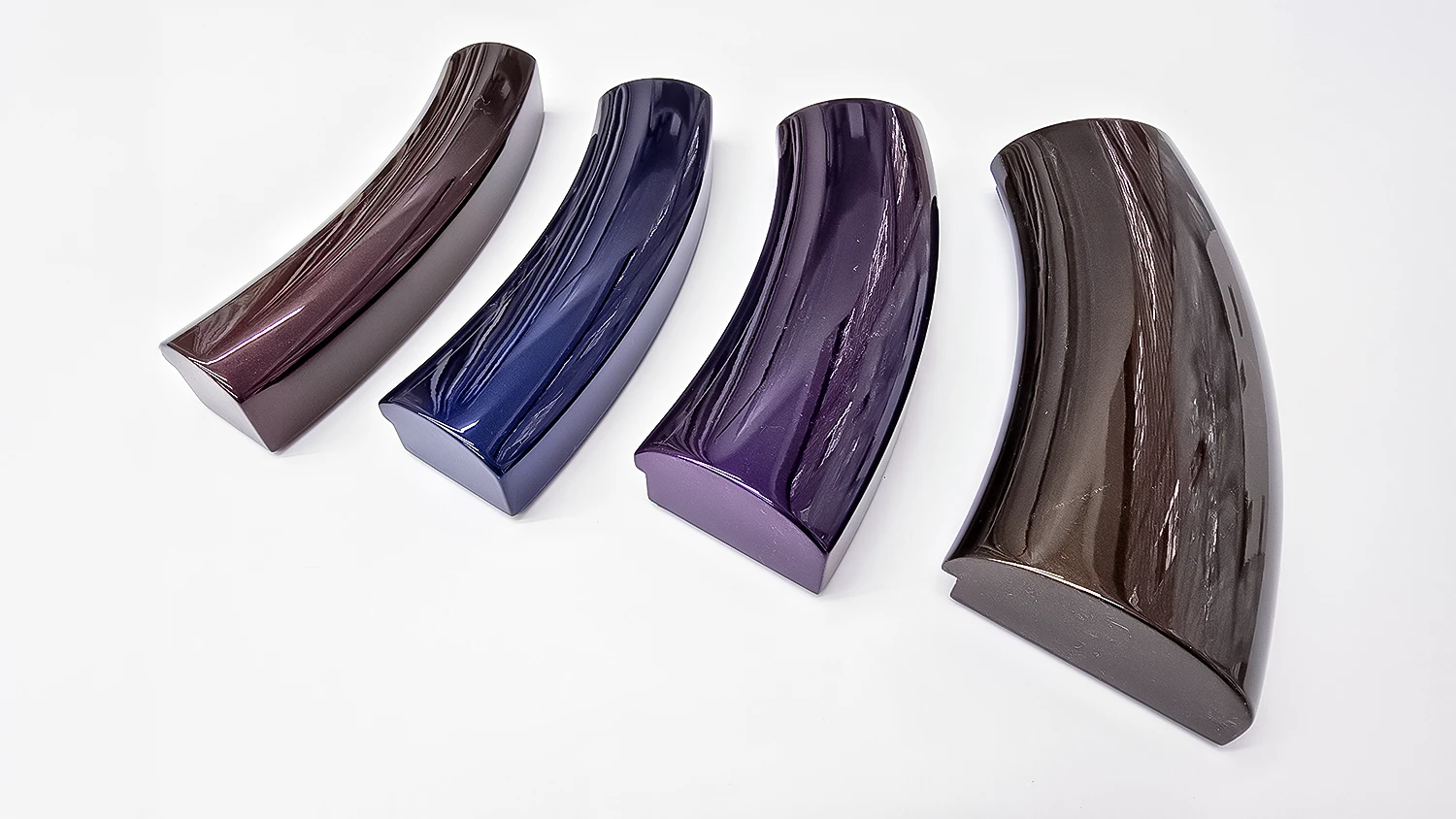 Four curved picture frame sections with high gloss painted finishes, brown, deep blue, deep purple and copper brown