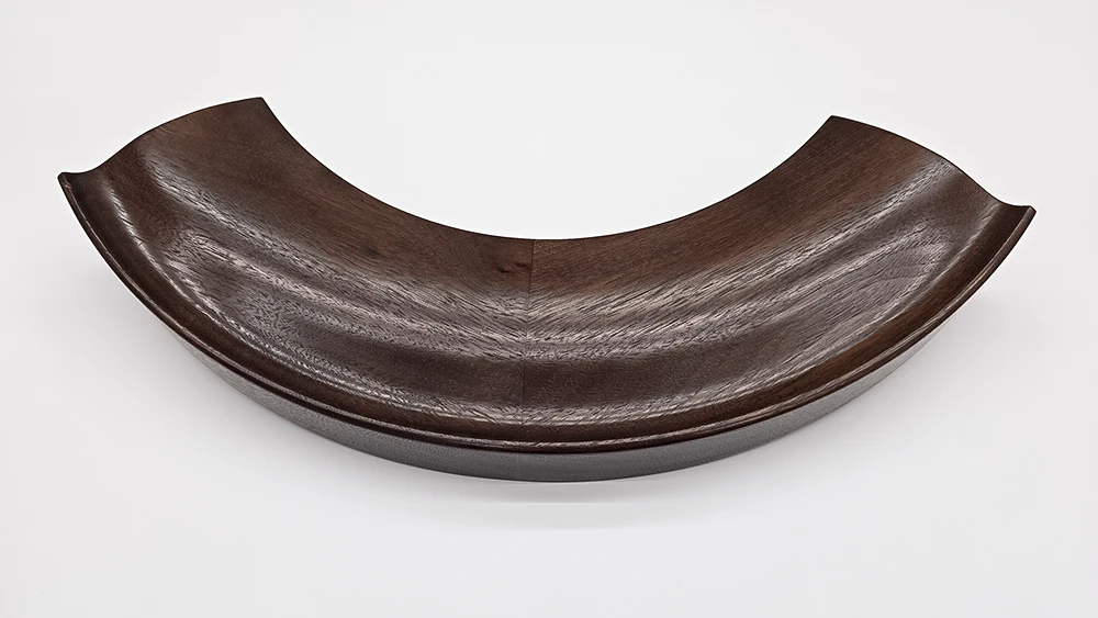 curved round mirror frame section on a white background. Frame made from walnut with a cushion profile