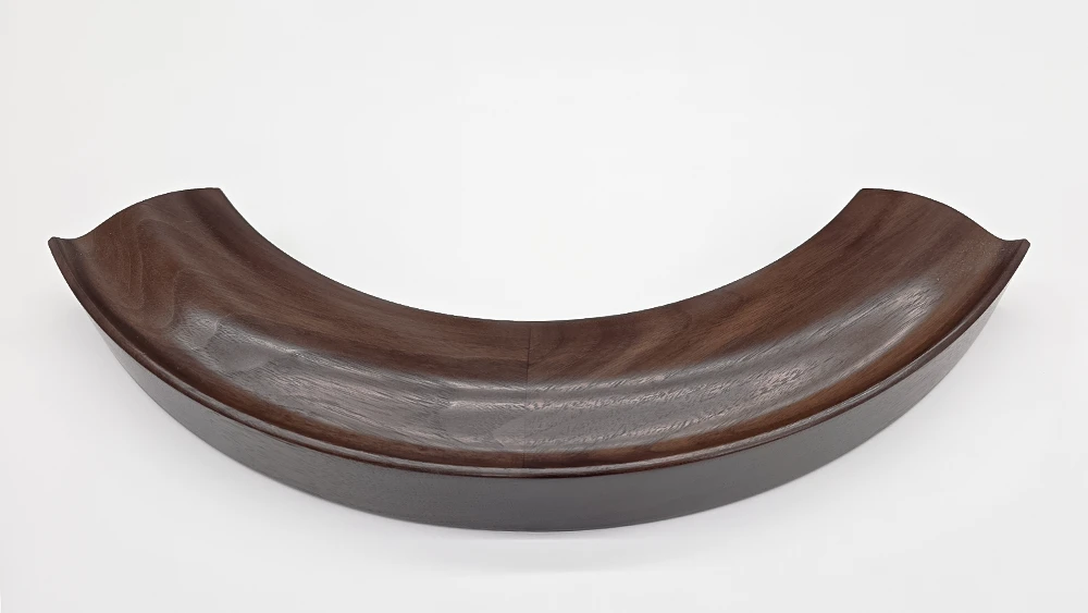curved section of a round mirror frame walnut cushion profile on a white background.