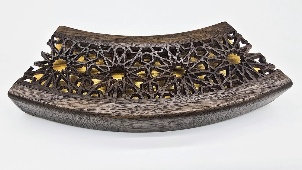 curved picture frame section with a carved walnut face in a delicate Islamic art inspired design and a gold base.