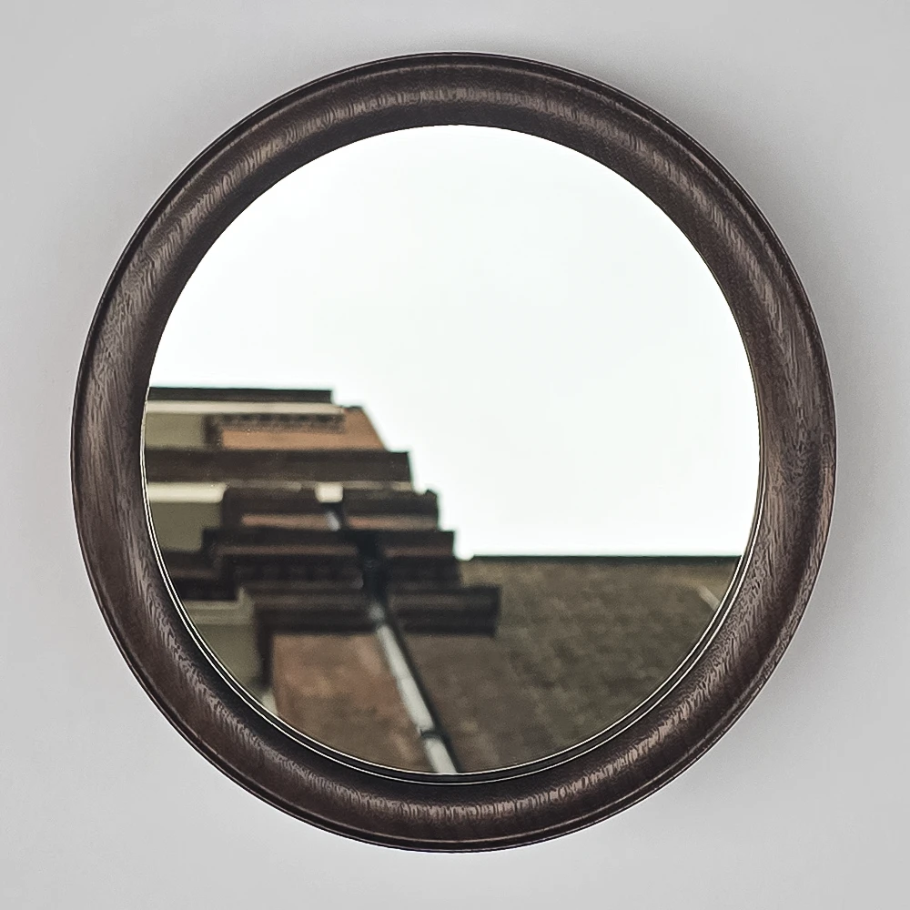 an oval mirror and frame made from walnut