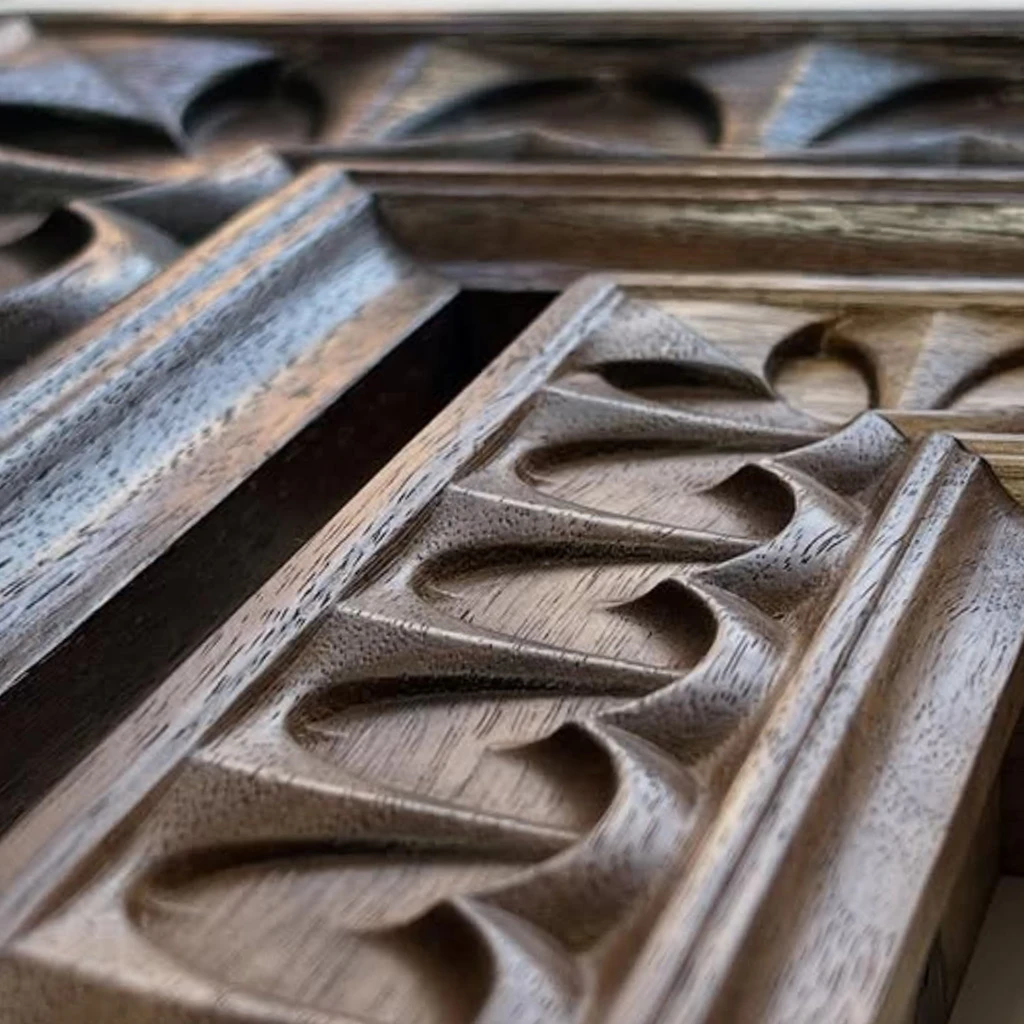 A close-up of a carved walnut picture frame corner