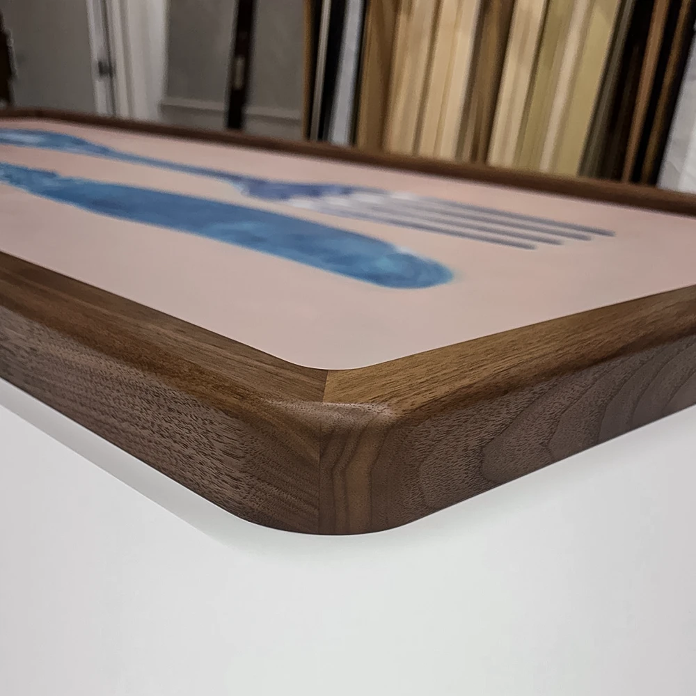 Close-up of a rounded corner on a walnut picture frame on a white background