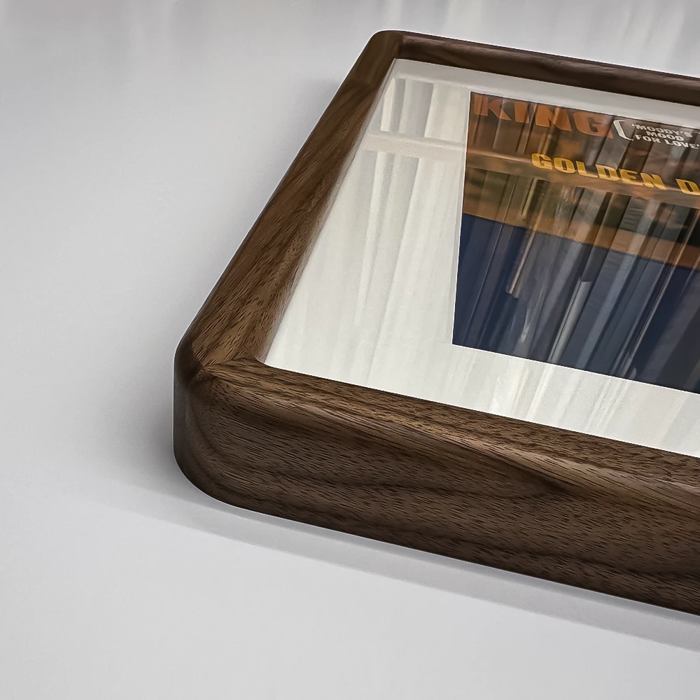 close-up of a rounded corner on a square walnut picture frame on a white background
