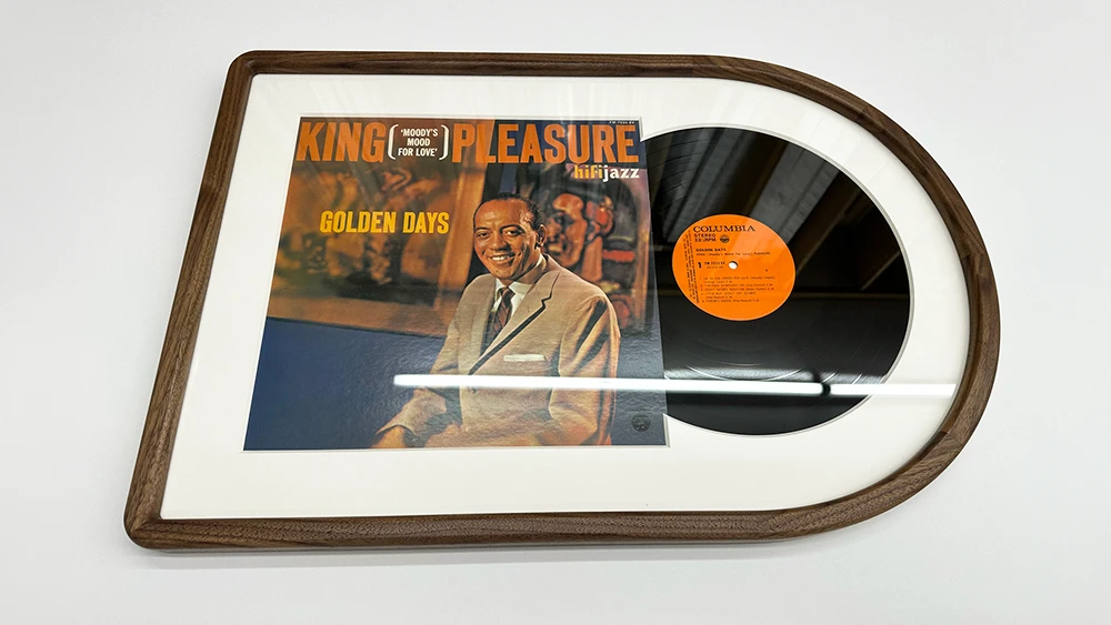 A framed record half-in half-out of the sleeve in a hybrid rounded corner walnut picture frame