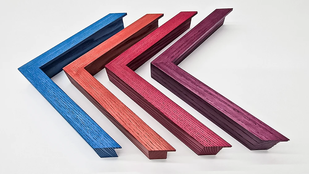 Four picture frame corners with brightly coloured wood stains on a white background