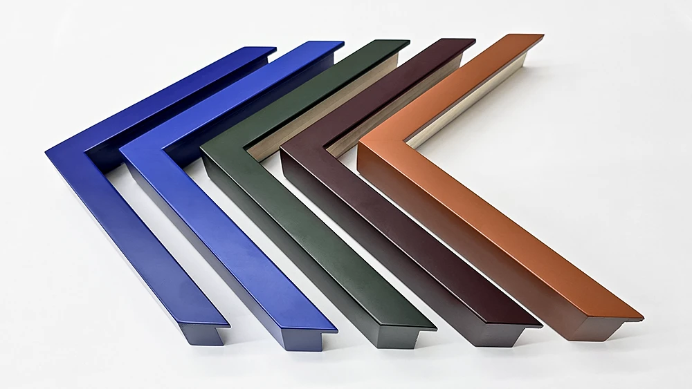 Five custom sprayed picture frame corners in different colours on a white background