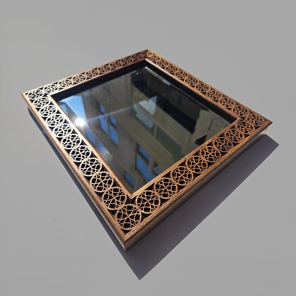 A carved walnut picture frame with a bevelled edge mirror showing a reflection of a Soho alleyway.