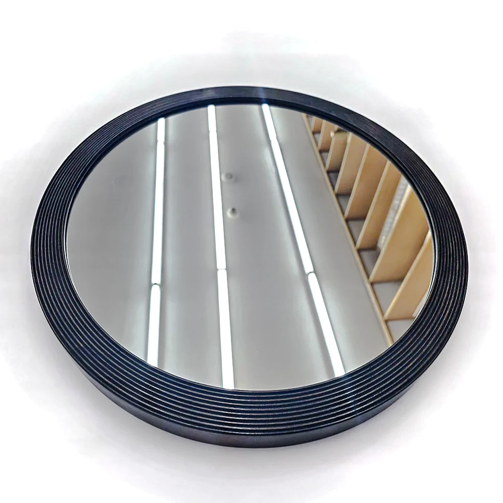 A round mirror with a black ribbed frame.