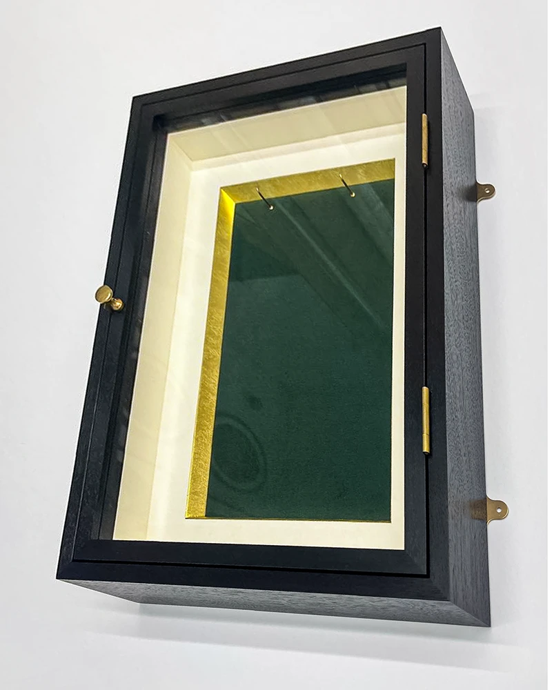 Shadow box display cabinet frame with front opening door. Made from black walnut with a gold and green velvet inside