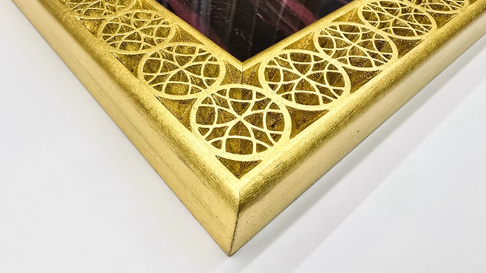 close up on the Qatar design custom carved picture frame in 22k gold.